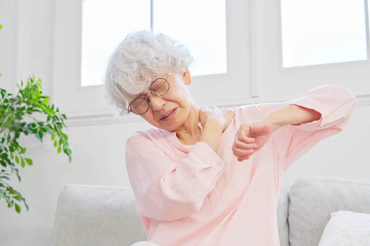 Elderly woman suffering from shoulder injury.
