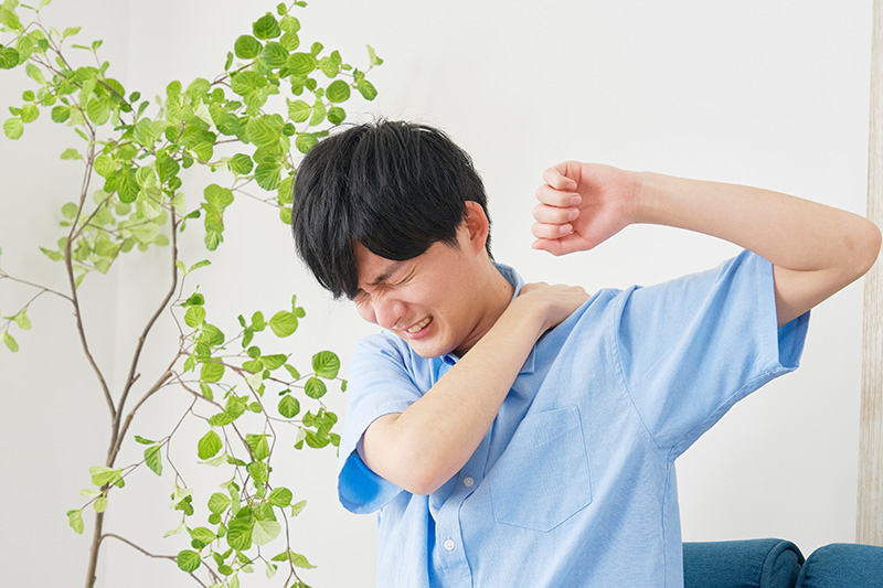 A young man in need of frozen shoulder treatment